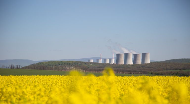 nuclear thermal power plant chimneys with field yellow rapeseed front them